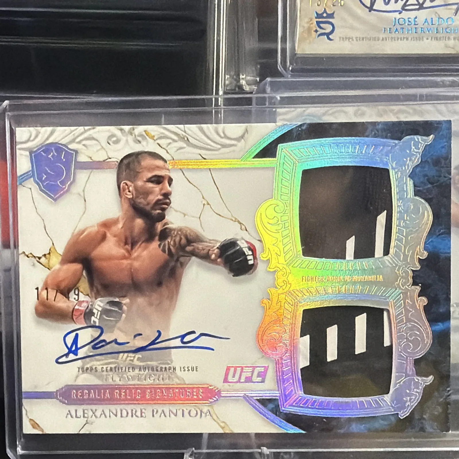 2025 Topps Royalty UFC Alexandre Pantoja Regalia Relic Signatures card with a signature and two fighter-worn patch windows, shown in a top loader