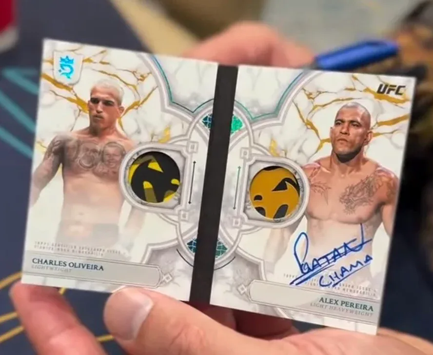 Charles Oliveira and Alex Pereira dual relic autograph booklet from 2026 Topps Royalty UFC, held open to show a patch window on each page and a blue signature on Pereira's page